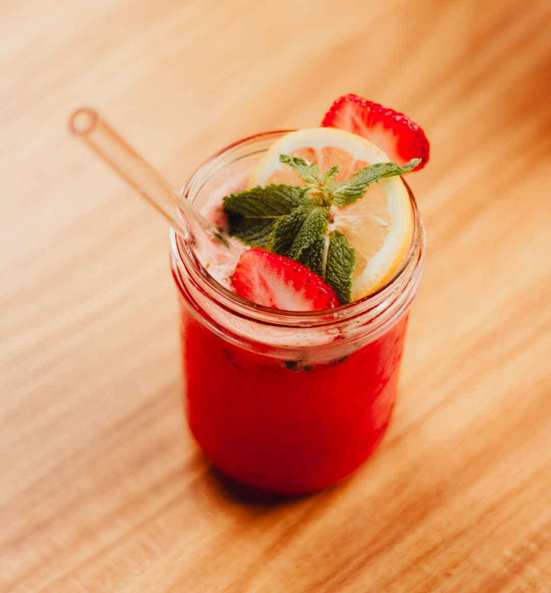 Strawberry Lemonade Mojito Mocktail garnished with fresh mint, strawberries and lemon